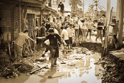A church team of mainly high school and college students helps clear mud and rubble to allow families access to the ground floors of their homes.  Note the level of mud, already hardened, on the right.