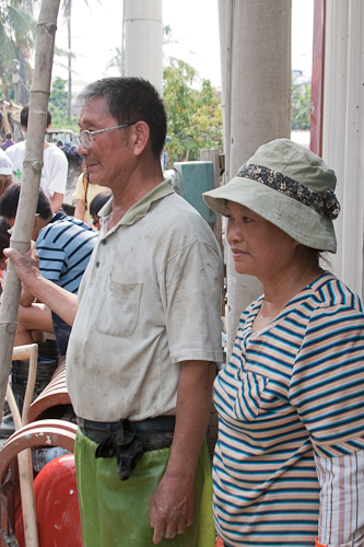 Mr. & Mrs. Tsai watch as volunteers clear mud and rubble from their house